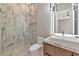 Bathroom featuring marble shower, glass door, modern vanity, and a unique light fixture at 1555 Eastbrook Dr, Sarasota, FL 34231
