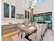 Bright dining room features stylish lighting, large windows, and a modern table with seating for eight at 1555 Eastbrook Dr, Sarasota, FL 34231