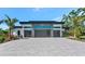 Modern home featuring a three-car garage, sleek architectural design, and attractive landscaping at 1555 Eastbrook Dr, Sarasota, FL 34231