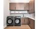 Functional laundry room featuring sleek cabinetry, modern washer/dryer, and counter space at 1555 Eastbrook Dr, Sarasota, FL 34231