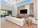 This living room boasts high ceilings, a large flat screen tv, and sliding doors to outdoor entertainment at 1555 Eastbrook Dr, Sarasota, FL 34231