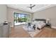 Primary bedroom featuring tray ceiling with fan and large windows with views of the backyard at 1555 Eastbrook Dr, Sarasota, FL 34231