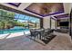 This patio features an outdoor dining space, television, fireplace, and view of the pool and neighborhood at 1555 Eastbrook Dr, Sarasota, FL 34231