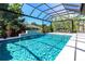 Stunning pool with waterfall feature and screened enclosure, perfect for relaxation and entertainment at 1555 Eastbrook Dr, Sarasota, FL 34231