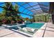 Beautiful outdoor pool with integrated sun loungers and spa, complemented by a screened enclosure at 1555 Eastbrook Dr, Sarasota, FL 34231