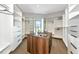 This walk-in closet features custom shelves and drawers, a center island, and a large window at 1555 Eastbrook Dr, Sarasota, FL 34231