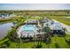 Aerial view of the community pool, tennis courts, and clubhouse, surrounded by lush landscaping and scenic views at 16161 61St E Ln, Parrish, FL 34219