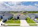 Aerial view showcases a gray home with a well-kept lawn and neighborhood pond views at 16161 61St E Ln, Parrish, FL 34219