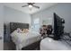 This bedroom features a gray upholstered headboard, soft carpet, and a ceiling fan at 16161 61St E Ln, Parrish, FL 34219