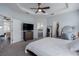 This main bedroom features tray ceilings, an ensuite bath, a ceiling fan and a closet at 16161 61St E Ln, Parrish, FL 34219