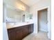 Bathroom with double sink vanity, large mirror, and neutral tile flooring at 16848 Rosedown Gln, Parrish, FL 34219