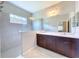 Modern bathroom featuring double sinks, sleek vanities, and a walk-in shower with tiled walls at 16848 Rosedown Gln, Parrish, FL 34219
