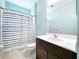Bathroom with light blue walls, white vanity, and gray and white striped shower curtain at 16848 Rosedown Gln, Parrish, FL 34219