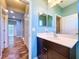 Well-lit bathroom featuring a modern vanity, large mirror, complemented by adjacent hallway and a glimpse of the home interior at 16848 Rosedown Gln, Parrish, FL 34219