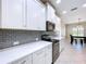 Modern kitchen featuring white cabinets, gray subway tile backsplash, and stainless steel appliances at 16848 Rosedown Gln, Parrish, FL 34219