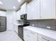 Modern kitchen with white cabinets, stainless steel appliances, and stylish backsplash at 16848 Rosedown Gln, Parrish, FL 34219