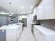Bright kitchen with stainless steel appliances, white cabinets, and a large island at 16848 Rosedown Gln, Parrish, FL 34219