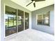 Covered lanai with a ceiling fan and sliding glass doors offering views of the lush backyard at 16848 Rosedown Gln, Parrish, FL 34219