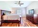 Spacious main bedroom featuring wood floors, ceiling fan, dresser, and a window with shutters at 16848 Rosedown Gln, Parrish, FL 34219