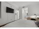 Neutral primary bedroom featuring a TV, ensuite bathroom, and doorway into the walk-in closet at 17902 Gawthrop Dr # 107, Bradenton, FL 34211