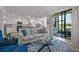 Bright living room with a comfortable gray sofa, blue pillows, and a sliding glass door leading to a patio at 17902 Gawthrop Dr # 107, Bradenton, FL 34211