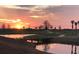 Scenic view of sunset over a pond with trees and a small bridge reflecting on the water at 17902 Gawthrop Dr # 107, Bradenton, FL 34211