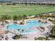 Aerial view of a luxury pool area with waterfalls, lounge chairs, palm trees and golfers on the course at 17902 Gawthrop Dr # 107, Bradenton, FL 34211