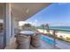 Relaxing balcony featuring wicker furniture, clear ocean views, and a view of the pool at 1800 Benjamin Franklin Dr # B310, Sarasota, FL 34236