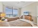 Bedroom with two twin beds, dresser, neutral walls, and ocean views through a sliding glass door at 1800 Benjamin Franklin Dr # B310, Sarasota, FL 34236