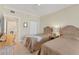Bright bedroom with twin beds, a ceiling fan and access to the laundry room at 1800 Benjamin Franklin Dr # B310, Sarasota, FL 34236