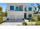 Modern two-story home with a two-car garage, balcony with glass railings, and manicured landscaping at 1842 Kenilworth St, Sarasota, FL 34231