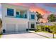 Contemporary white house with a balcony and a two-car garage, highlighted by a colorful sunset at 1842 Kenilworth St, Sarasota, FL 34231