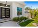 Modern home entryway featuring double doors, manicured landscaping, and a decorative sculpture at 1842 Kenilworth St, Sarasota, FL 34231