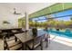 Outdoor dining and living space, with a view of the sparkling pool and lush landscaping at 1842 Kenilworth St, Sarasota, FL 34231
