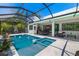 Beautiful pool and hot tub in screened enclosure with poolside seating and open access to the home's interior at 1842 Kenilworth St, Sarasota, FL 34231