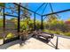 Backyard screened-in pool area with lounge seating, tropical landscaping, and overhead sun protection at 1842 Kenilworth St, Sarasota, FL 34231