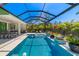 A screened-in pool area features a swimming pool with fountains, lounge chairs, and outdoor dining space at 1842 Kenilworth St, Sarasota, FL 34231
