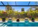 The backyard screened-in pool features two elevated fire bowls overlooking the serene, clear water at 1842 Kenilworth St, Sarasota, FL 34231