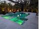 At dusk the backyard pool and hot tub in a screened enclosure is aglow with lit water and fire features at 1842 Kenilworth St, Sarasota, FL 34231