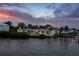 Waterfront home with manicured landscaping and sunset sky reflected in the calm water at 1907 4Th W St, Palmetto, FL 34221