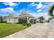 Charming home with a white carport, lush landscaping, and a light-colored brick driveway at 1907 4Th W St, Palmetto, FL 34221