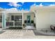 Charming home exterior with a covered porch featuring decorative lattice and a bright teal front door at 1907 4Th W St, Palmetto, FL 34221