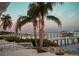 Picturesque waterfront view with palm trees, private docks, a white picket fence, and tranquil waters at 1907 4Th W St, Palmetto, FL 34221