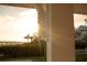 Waterfront home and dock as seen through a sunlit porch, showcasing the property's coastal charm at 1907 4Th W St, Palmetto, FL 34221