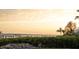 Panoramic view of waterfront property with private dock, lush hedges, and serene sky at sunset at 1907 4Th W St, Palmetto, FL 34221