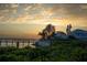 Scenic waterfront property with a private dock, lush greenery, and a beautiful sunset in the sky at 1907 4Th W St, Palmetto, FL 34221