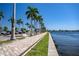 Picturesque waterfront view featuring a paved walkway lined with palm trees, set against a beautiful city skyline at 1907 4Th W St, Palmetto, FL 34221