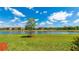 Beautiful backyard with lush green grass and mature tree offering serene views of the lake at 20398 Lagente Cir, Venice, FL 34293