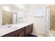 Bright bathroom featuring a large vanity with a white countertop and tiled shower/tub combo at 20398 Lagente Cir, Venice, FL 34293