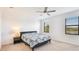 Bright bedroom with ceiling fan, two windows, and floral bedding at 20398 Lagente Cir, Venice, FL 34293